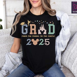 May include: Black t-shirt with a colorful graphic that says "GRAD" with a Mickey Mouse head and castle silhouette. The text below says "From the tassel to the castle 2025".