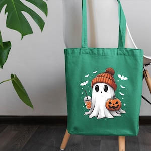 a green bag with a ghost holding a pumpkin