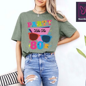 May include: Green t-shirt with a graphic of sunglasses and the text "Party Like The 80's".
