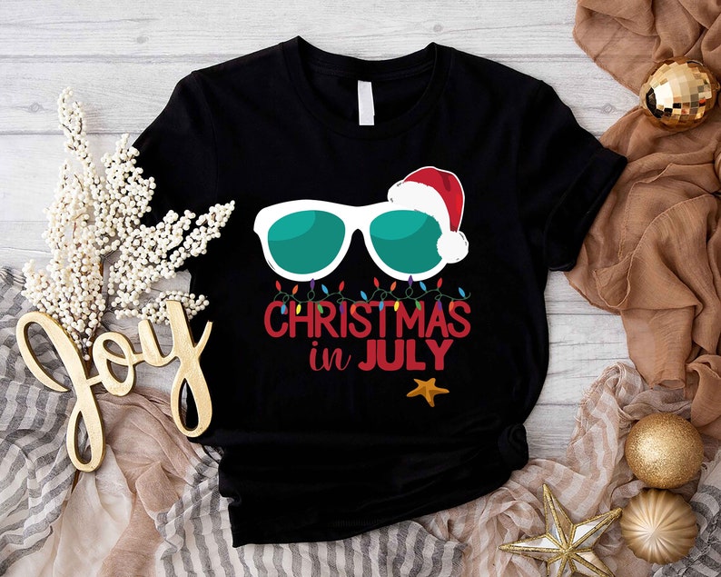 a black t - shirt with the words merry christmas in july on it