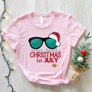 a pink t - shirt with sunglasses and a santa hat on it