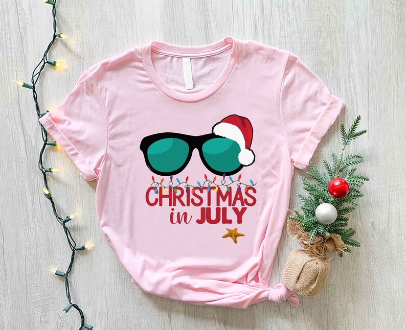 a pink t - shirt with sunglasses and a santa hat on it