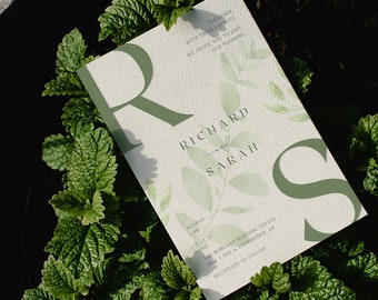 May include: A wedding invitation with the names Richard and Sarah, surrounded by green leaves and the letter "R" and "S". The invitation includes the date, time, and location of the wedding.