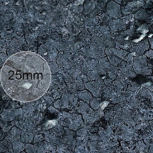 K&ouml;nnte beinhalten: Nahaufnahme einer dunkelgrauen, strukturierten Oberfl&auml;che mit einem runden wei&szlig;en Etikett, auf dem "25 mm" steht.