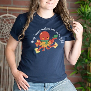 May include: A navy blue t-shirt with a red octopus illustration holding various school supplies. The text "Many hands makes the work light" is printed around the octopus.