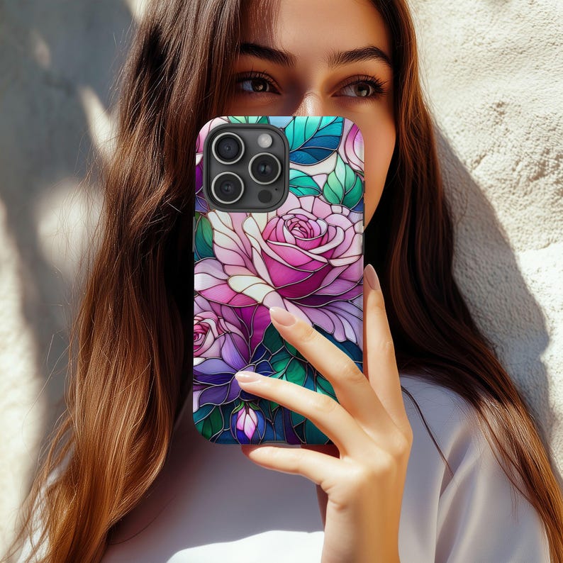 May include: A smartphone case featuring a stained-glass style floral design. The case showcases pink and purple roses with green leaves against a blue background. The case has a glossy finish and a camera cutout.