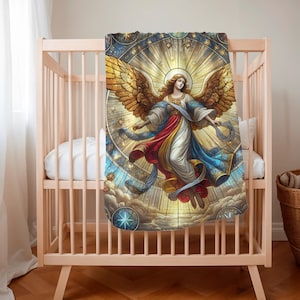 May include: A baby blanket featuring a detailed illustration of an angel with golden wings, flowing robes in red, white, and blue, and a halo. The design is set against a stained-glass style background with celestial elements.