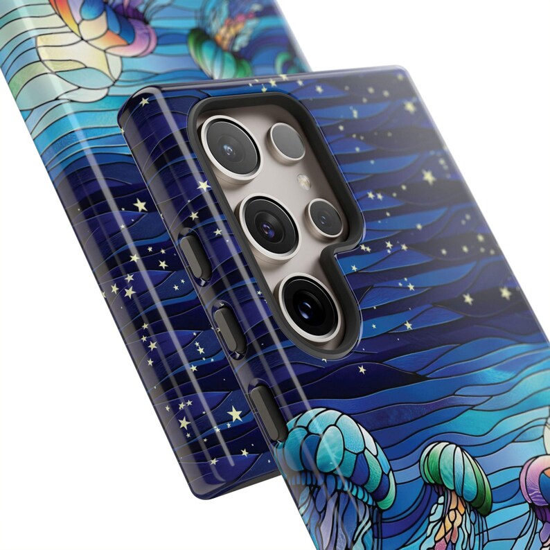 May include: A phone case with a vibrant, artistic design featuring jellyfish and a starry night sky in shades of blue, teal, and purple. The case has a glossy finish and a camera cutout.