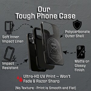 May include: Black phone case with the text "Our Tough Phone Case". Features include a soft inner impact liner, polycarbonate outer shell, and matte or glossy finish. The case has a graphic of a man with the text "Embrace the Gray".