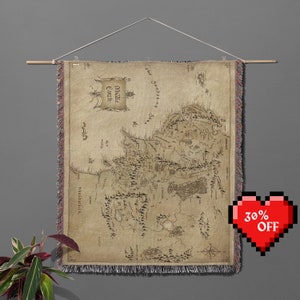 Può includere: Un arazzo da parete con una mappa dettagliata della Terra di Mezzo dal Signore degli Anelli. La mappa è stampata su uno sfondo beige con linee e testo marroni. Il testo include "The Sundering Seas" e "Middle-earth".