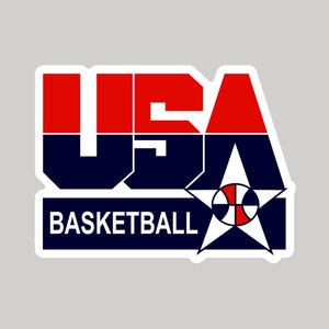 May include: A white sticker with a red, white, and blue USA Basketball logo. The logo features the word "USA" in bold, block letters with a basketball and star in the center.