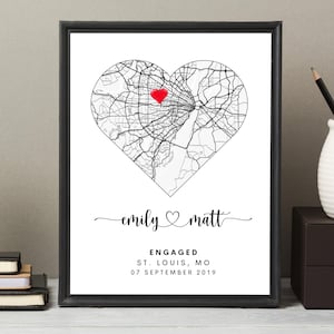 Puede incluir: Impresión enmarcada con un mapa en forma de corazón de St. Louis, MO, marcado con un corazón rojo. Los nombres "emily" y "matt" están en cursiva, con "engaged" y la fecha "07 de septiembre de 2019" debajo. Marco negro.
