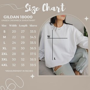 May include: A Gildan 18000 unisex crewneck sweatshirt size chart in inches. The chart lists sizes S through 4XL with corresponding width, length, and sleeve measurements. A white sweatshirt is shown with black lines indicating width and length.