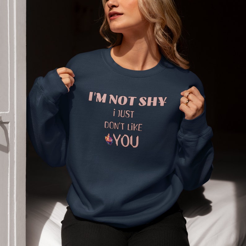 May include: A navy blue sweatshirt with the text 'I'M NOT SHY i JUST DON'T LIKE YOU' printed in pink on the front.