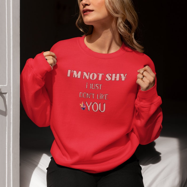 May include: Red sweatshirt with the text 'I'M NOT SHY i JUST DON'T LIKE YOU' printed on the front in pink lettering.