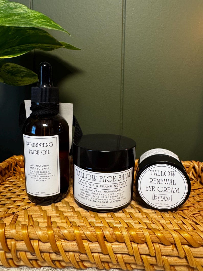 May include: A brown glass dropper bottle labeled Nourishing Face Oil, a black jar labeled Tallow Face Balm Lavender & Frankincense, and a smaller black jar labeled Tallow Renewal Eye Cream by Evara Apothecary, all containing 2oz or 15ml.