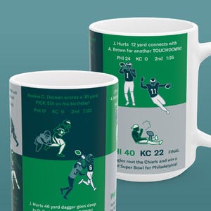 May include: White ceramic mugs with green and gray graphics depicting football plays and scores. Text includes "J. Hurts 12 yard connects with A. Brown for another TOUCHDOWN!" and "PHI 40 KC 22 FINAL".