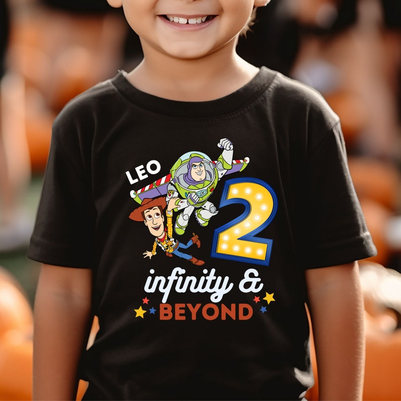 May include: Black t-shirt with a Toy Story theme. The shirt features Woody and Buzz Lightyear, a number 2, and the text "LEO infinity & BEYOND".