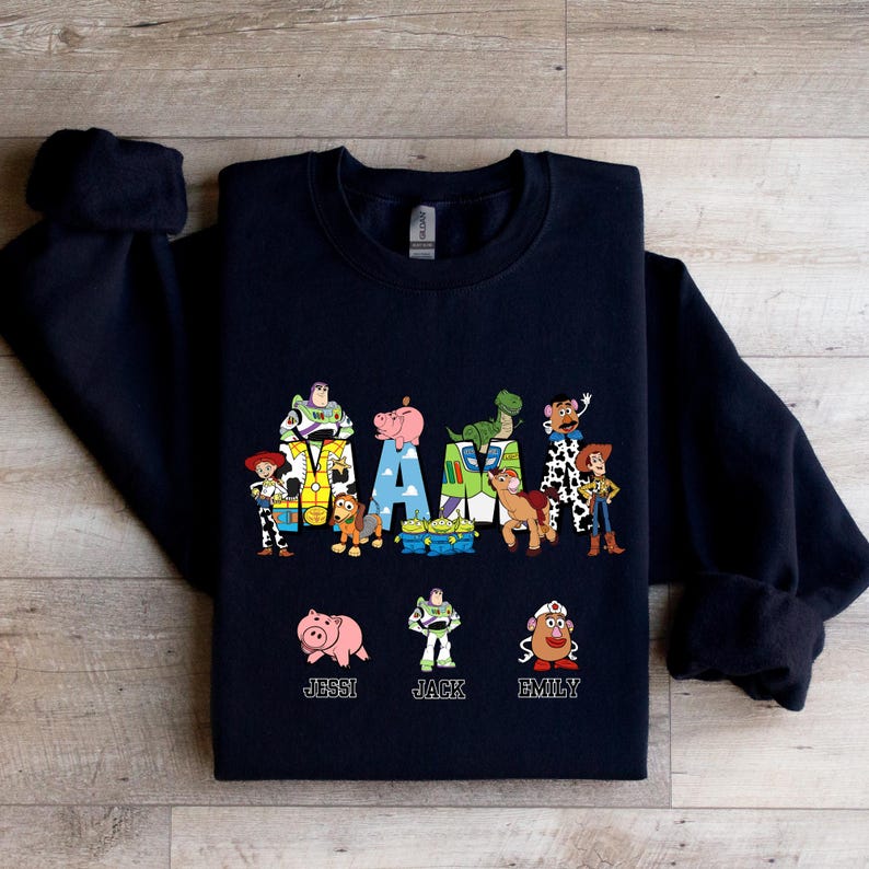 Może przedstawiać: Czarna bluza z motywem Toy Story. Słowo "MAMA" jest napisane postaciami z filmu. Pod słowem znajdują się imiona "Jessi", "Jack" i "Emily".