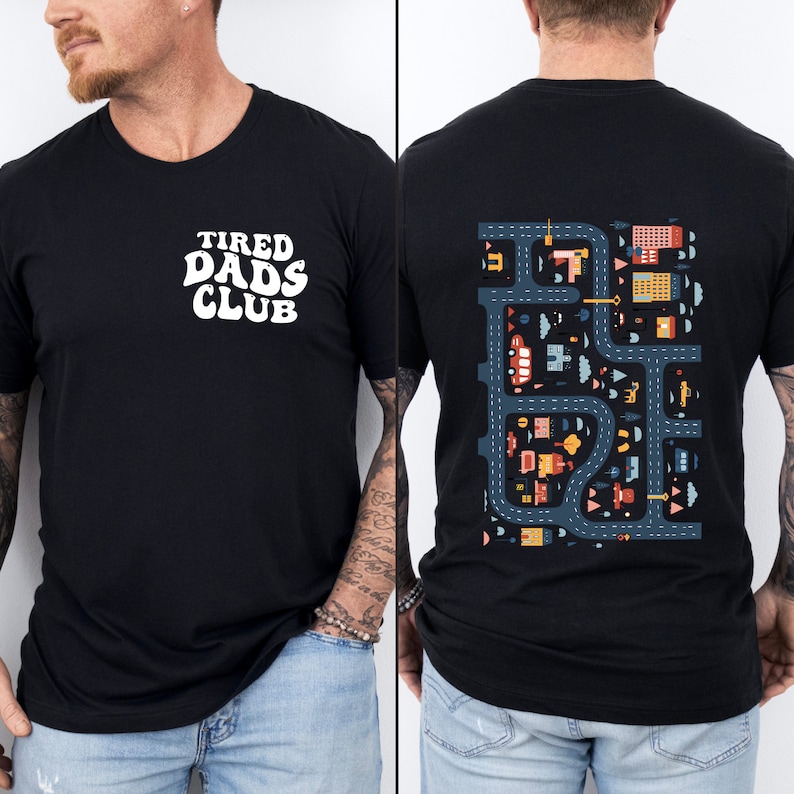 Puede incluir: Camiseta negra con el texto "TIRED DADS CLUB" en blanco en la parte delantera y una escena de ciudad colorida en la parte posterior.