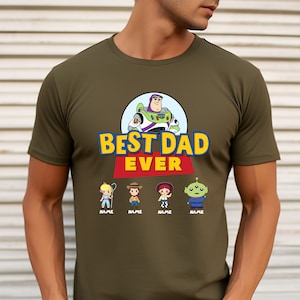 May include: Olive green t-shirt featuring a graphic of Buzz Lightyear and the text "BEST DAD EVER." Below the text are cartoon characters with the word "NAME" under each. The shirt is made of a soft material.