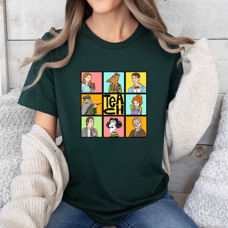 May include: Dark green t-shirt featuring a colorful graphic with nine cartoon portraits and the word "TEACH". The portraits include a woman with flowers, a bear in a suit, a man in a suit, a man with a beard, a woman with a pointer, a woman with flowers, a man in a suit, a woman with a black and white hairstyle, and an older man.
