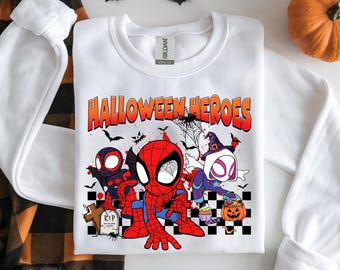 May include: White crewneck sweatshirt with a colorful graphic featuring Spider-Man and other characters with the text "HALLOWEEN HEROES". The design includes bats, a tombstone, and a jack-o'-lantern, perfect for Halloween.