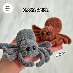Könnte beinhalten: Zwei gehäkelte Spinnen, eine graue und eine rostfarbene, werden gezeigt. Die graue Spinne ist im Fokus, mit schwarzen Augen und detaillierten Beinen. Der Text "Crochet Spider" befindet sich über den Spinnen, und "No Sew!" befindet sich unten rechts. "PDF Pattern Only" ist in einem weißen Kreis.