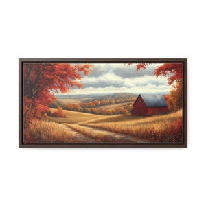 May include: A framed canvas print depicting a rural scene with a red barn and a dirt track through fields of golden grass. The scene is framed by trees with vibrant red and orange leaves, under a cloudy sky.