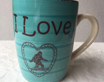 Valentine's Day I love (heart) cowboy lasso Sasquatch Turquoise Blue and Cream Colored Porcelain 12 oz. Coffee Cup
