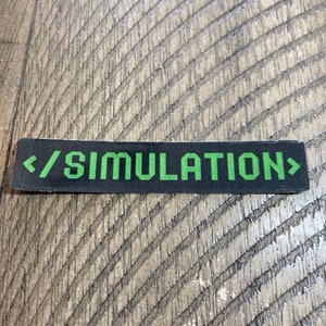 May include: Black and green sticker with the text "/simulation" in green letters with angled brackets on either side.