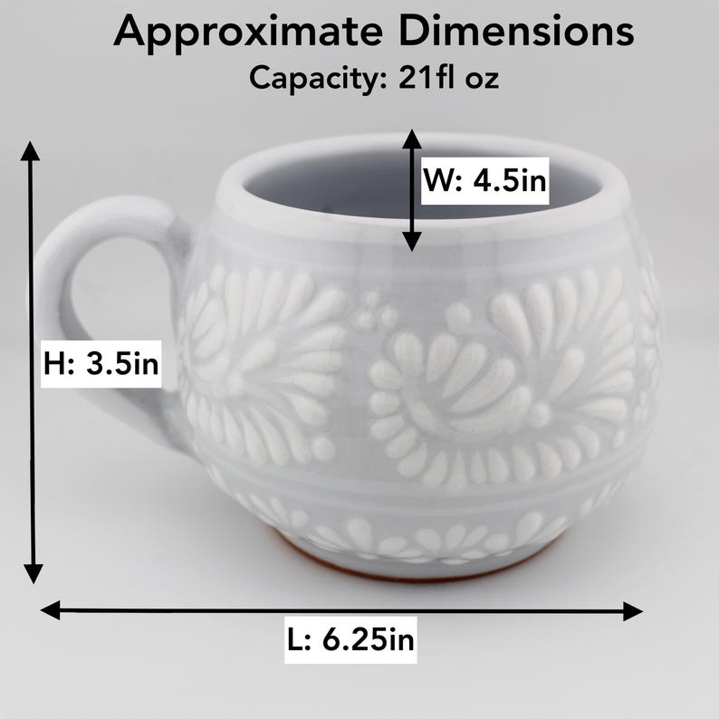 Op de afbeelding: Een lichtgrijze keramische mok met een wit reli&euml;f bloemenpatroon. De mok heeft een inhoud van 621 ml, een hoogte van 8,89 cm, een breedte van 11,43 cm en een lengte van 15,88 cm. De onderkant van de mok toont een roodbruine kleikleur.