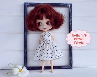 May include: A red-haired Blythe doll wearing a white dress with black polka dots. The doll is standing in a black picture frame against a white wall. The text "Blythe 1/6 Pattern Tutorial" is written in a pink speech bubble.