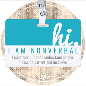 May include: A turquoise blue name tag with white text that reads "hi." and "I AM NONVERBAL. I can't talk but I can understand people. Please be patient and inclusive."