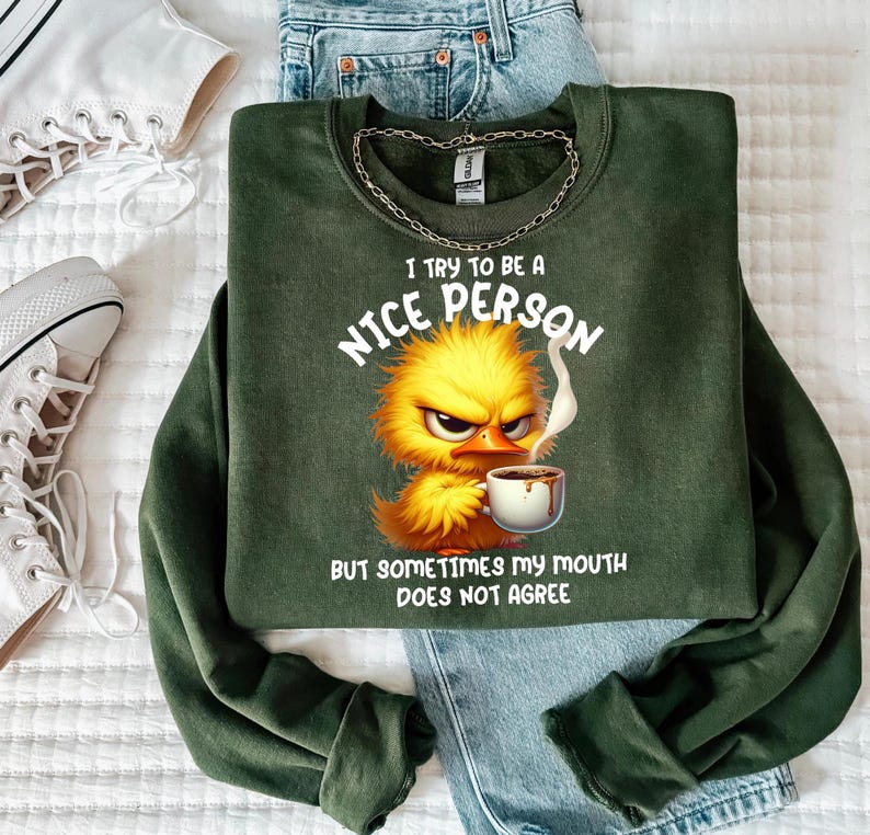 Pu&ograve; includere: Felpa verde con un pulcino dei cartoni animati che tiene una tazza di caff&egrave;. Il testo sulla felpa recita "Cerco di essere una persona gentile, ma a volte la mia bocca non &egrave; d'accordo."