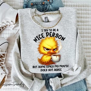 Pu&ograve; includere: Felpa grigia con un uccello giallo dei cartoni animati che tiene una tazza di caff&egrave;. Il testo sulla felpa dice "Cerco di essere una persona gentile, ma a volte la mia bocca non &egrave; d'accordo."