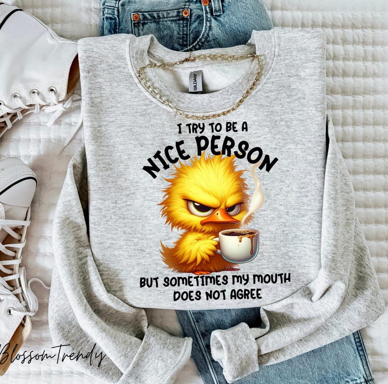 Pu&ograve; includere: Felpa grigia con un uccello giallo dei cartoni animati che tiene una tazza di caff&egrave;. Il testo sulla felpa dice "Cerco di essere una persona gentile, ma a volte la mia bocca non &egrave; d'accordo."