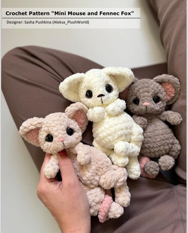 May include: Three crocheted plush toys: a cream-colored mouse, a light brown mouse, and a gray mouse. The toys have large black eyes, pink accents, and are made from a soft, textured yarn. The text "Crochet Pattern 'Mini Mouse and Fennec Fox'" is visible.