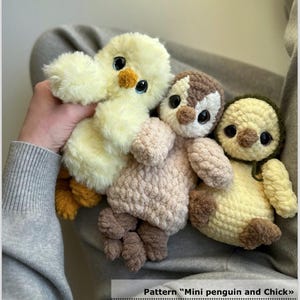 Op de afbeelding: Drie handgemaakte gehaakte pluche speelgoed: een gele kuiken, een pinguïn met bruine en witte details en een gele pinguïn met een groene hoed. Het speelgoed heeft grote, expressieve ogen en is gemaakt van zacht, pluizig garen. Het patroon is "Mini penguin and Chick".