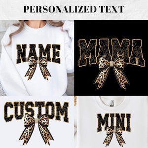 Könnte beinhalten: Vier weiße Sweatshirts mit schwarzem Text und einer Schleife im Leopardenmuster. Der Text auf den Sweatshirts lautet "NAME", "MAMA", "CUSTOM" und "MINI".