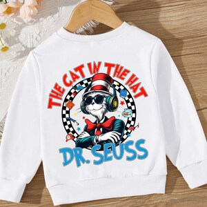 Peut inclure: Sweat-shirt blanc avec un graphique color&eacute; du Chat dans le Chapeau portant un casque et des lunettes de soleil. Le texte "The Cat in the Hat" et "Dr. Seuss" est imprim&eacute; sur le sweat-shirt.