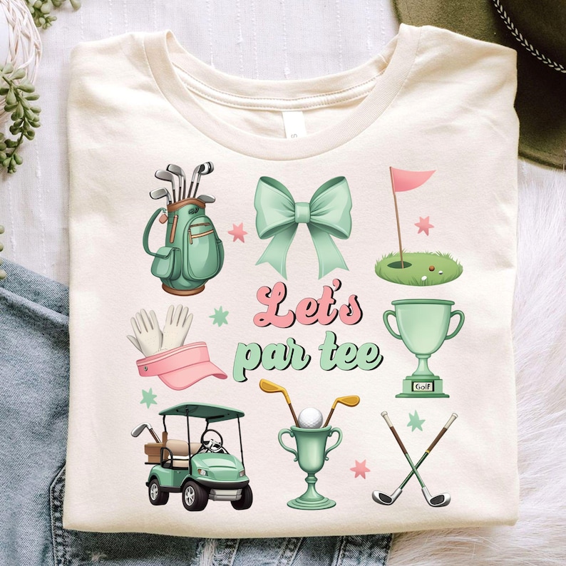 May include: A beige t-shirt with a green golf bag, a pink visor, a green golf trophy, a green golf cart, a green golf flag, two crossed golf clubs, a pink bow, and the text "Let's par tee".