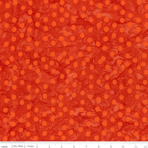 May include: Orange fabric with a white marbled pattern and orange polka dots.