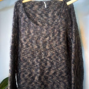 May include: A brown and black fuzzy knit sweater with a scoop neck and long sleeves.