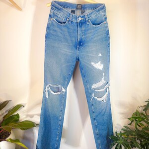 Op de afbeelding: Lichtblauwe denim jeans met distressed details en een rechte pijp. De jeans heeft een hoge taille en is gemaakt door het merk "Bdg".