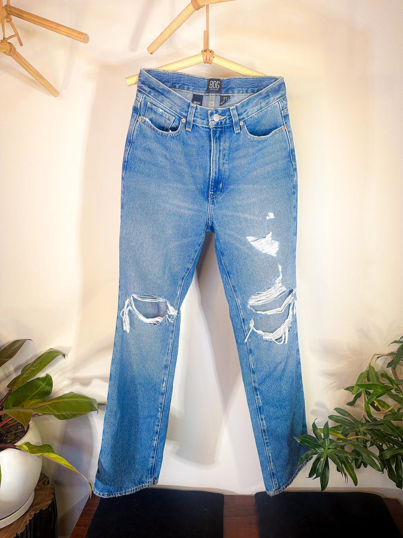 Op de afbeelding: Lichtblauwe denim jeans met distressed details en een rechte pijp. De jeans heeft een hoge taille en is gemaakt door het merk "Bdg".