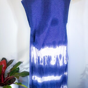 May include: A sleeveless maxi dress with a tie-dye pattern in shades of blue and white. The dress has a relaxed fit and a slightly gathered waist.
