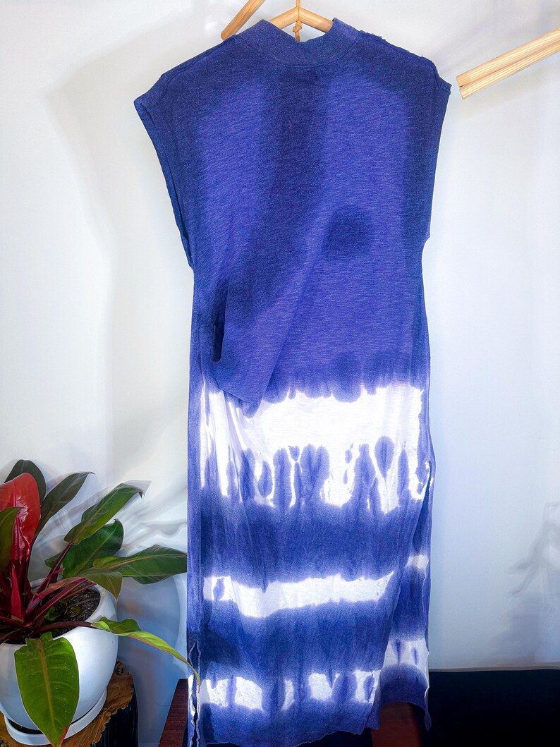 May include: A sleeveless maxi dress with a tie-dye pattern in shades of blue and white. The dress has a relaxed fit and a slightly gathered waist.