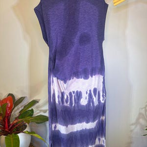 May include: A purple and white tie-dye sleeveless dress with a high neck and a side slit. The dress is made of a soft, lightweight fabric.