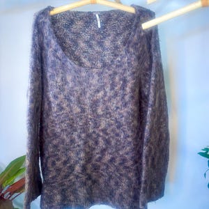 May include: A brown and beige fuzzy knit sweater with a scoop neck and long sleeves.